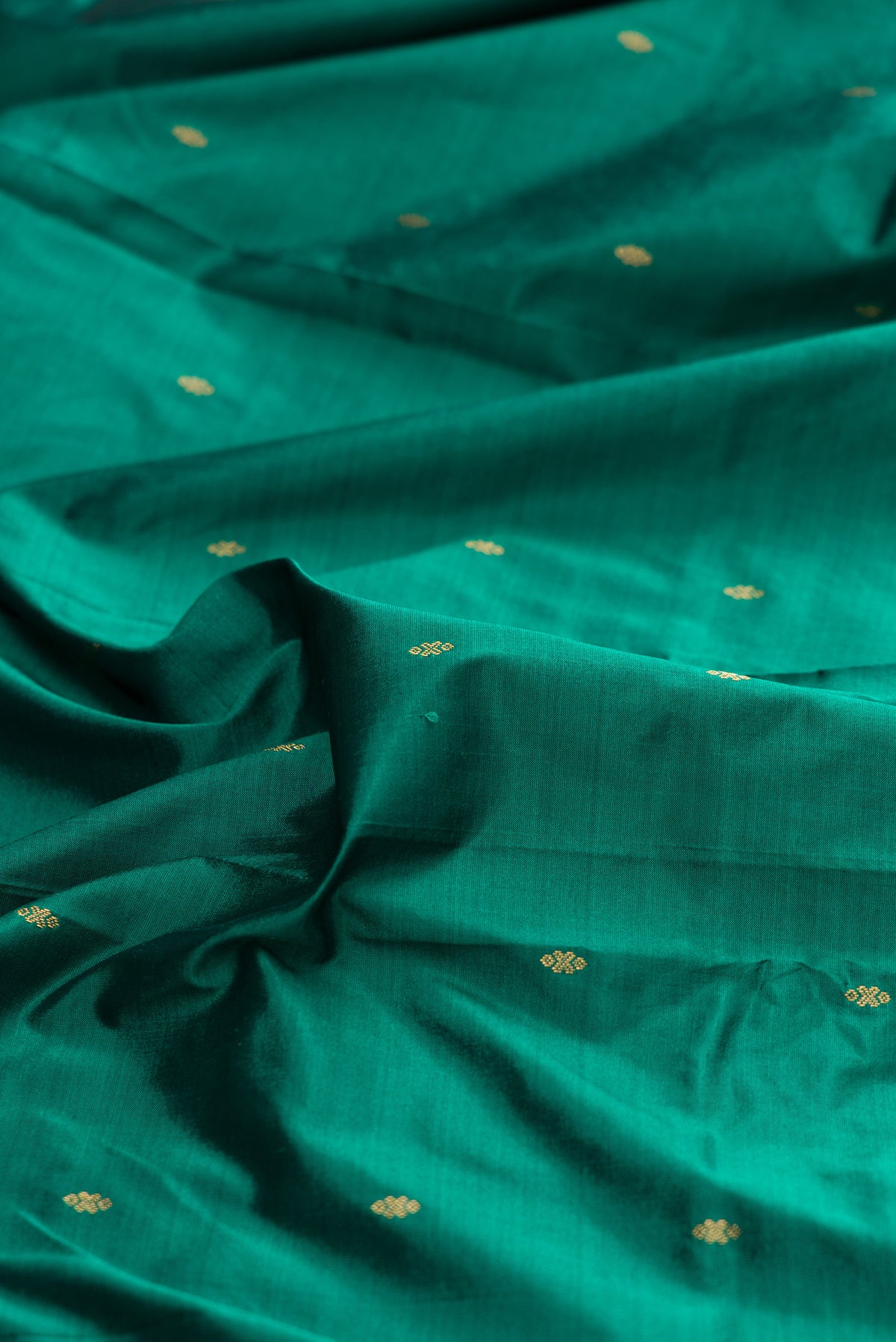 Close up of Pure Silk Green Bangalore Saree with Zari Butta on the body and Temple Border.  displaying folds