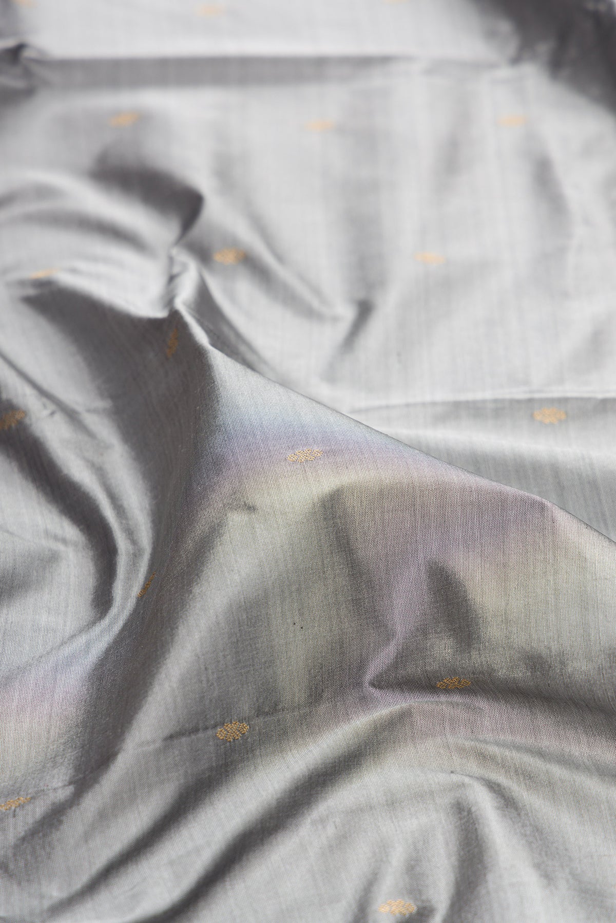 Close up of Pure Silk Grey Bangalore Saree with Zari Butta on the body and Temple Border.  displaying folds