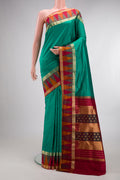 Pure Silk Green Bangalore Saree with Zari Butta on the body and Temple Border.  displayed on a mannequin