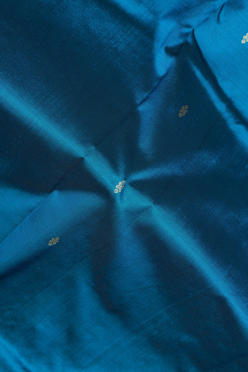 Close up of Pure Silk Peacock Blue Bangalore Saree with Zari Butta on the body and Temple Border.  displaying folds