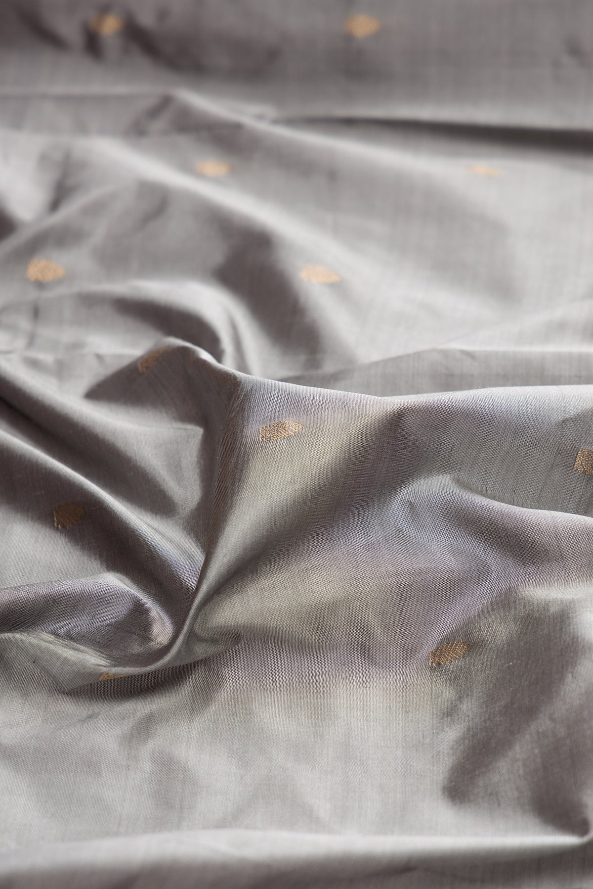 Close up of Pure Silk Grey Bangalore Saree with Zari Butta on the body and Zari Border.  displaying folds