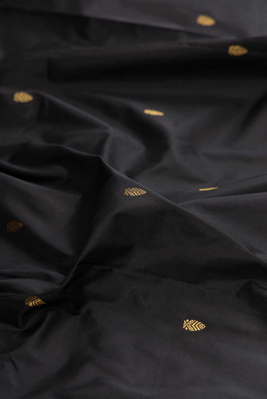 Close up of Pure Silk Black Bangalore Saree with Zari Butta on the body and Zari Border.  displaying folds