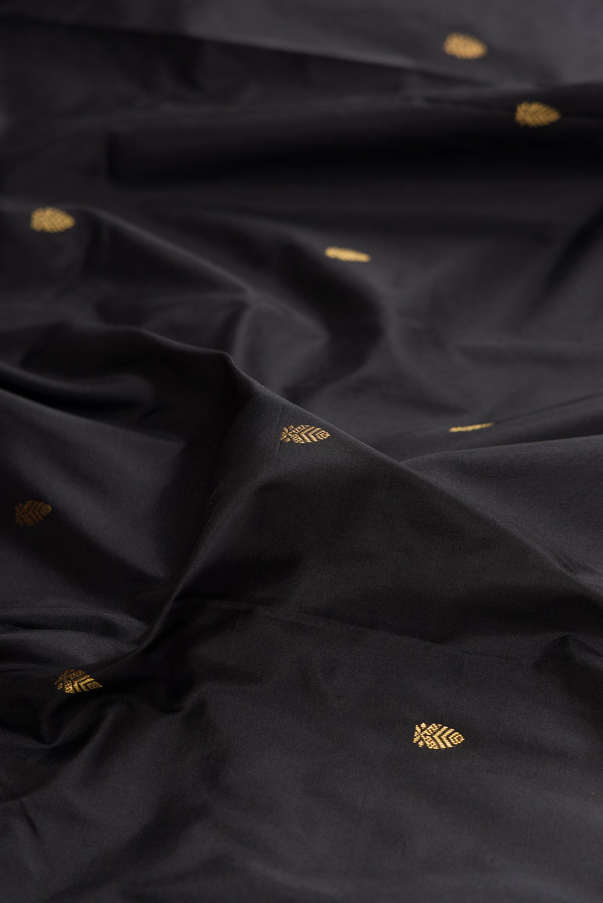 Close up of Pure Silk Black Bangalore Saree with Zari Butta on the body and Zari Border.  displaying folds