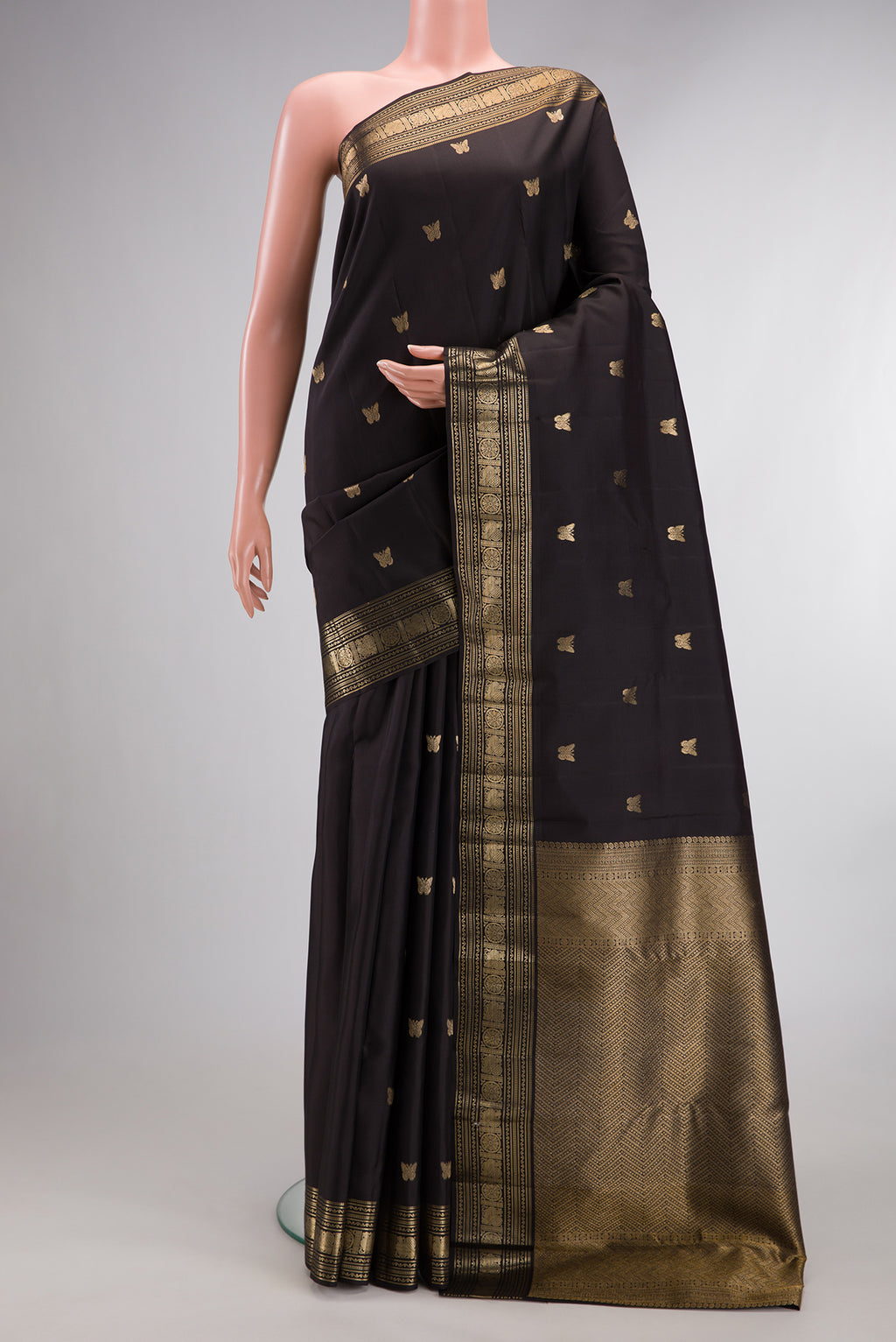 Pure Silk Black Kanjivaram Saree with Zari Butta on the body and Zari Border.  displayed on a mannequin