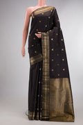 Pure Silk Black Kanjivaram Saree with Zari Butta on the body and Zari Border.  displayed on a mannequin