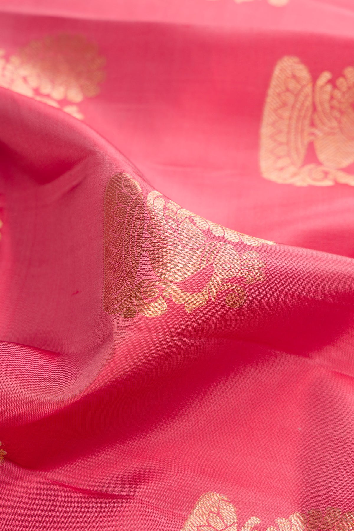 Close up of Pure Silk Coral Kanjivaram Saree with Zari Butta on the body and Zari Border.  displaying folds