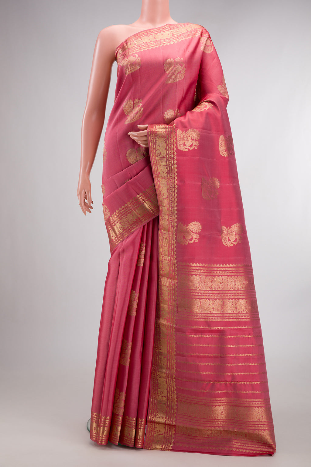 Pure Silk Coral Kanjivaram Saree with Zari Butta on the body and Zari Border.  displayed on a mannequin