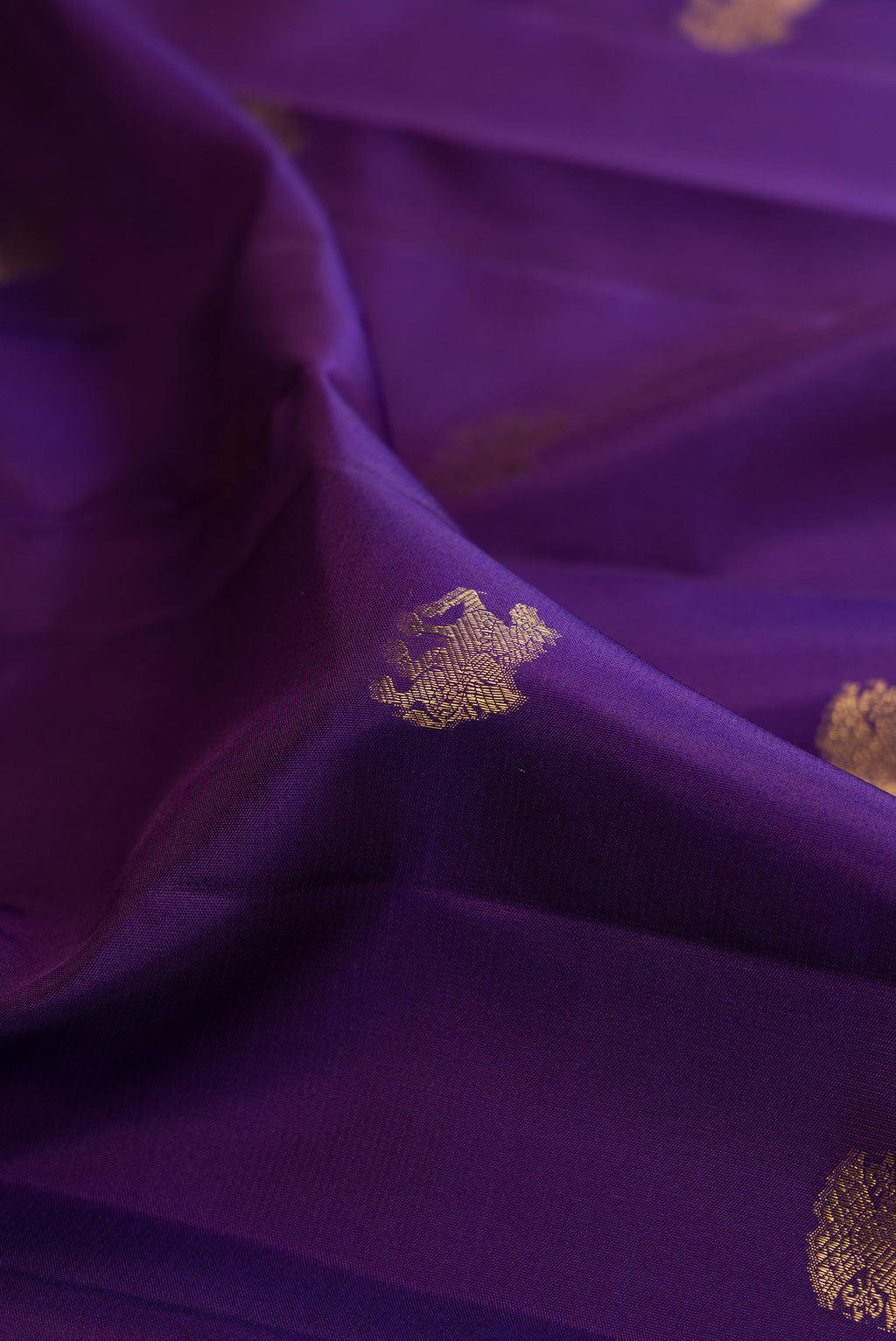 Close up of Pure Silk Violet Dual Tone Kanjivaram Saree with Zari Butta on the body and Zari Border.  displaying folds