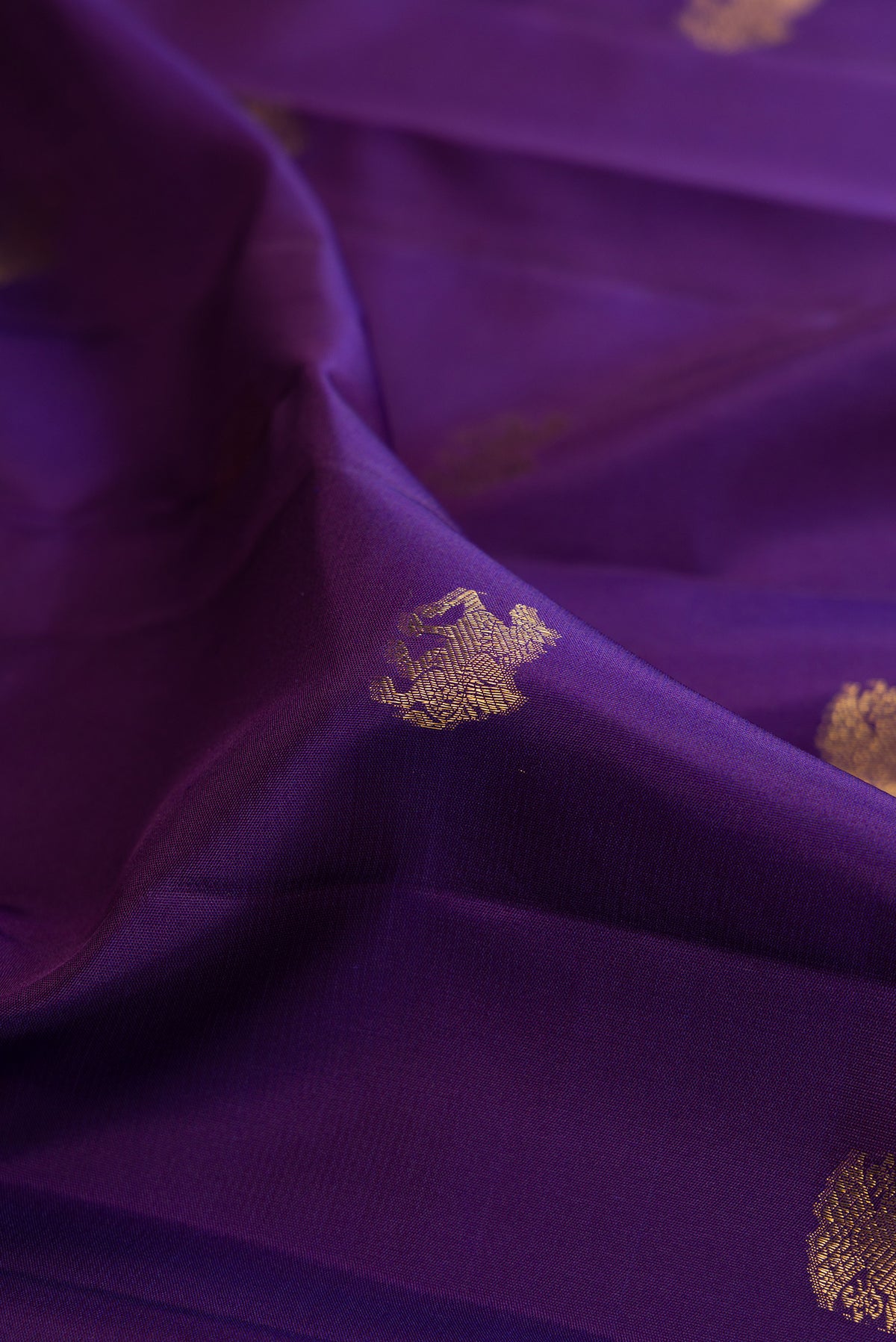 Close up of Pure Silk Violet Dual Tone Kanjivaram Saree with Zari Butta on the body and Zari Border.  displaying folds