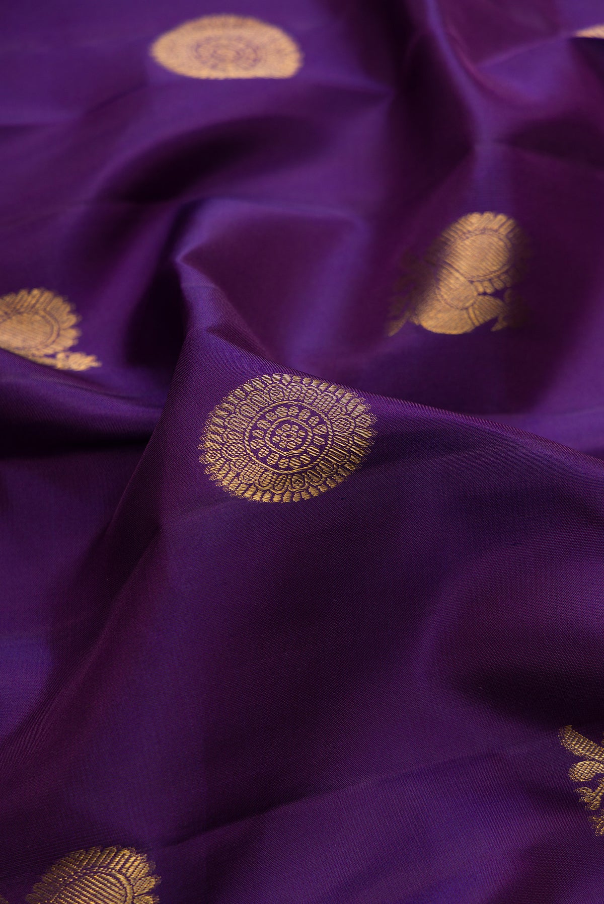 Close up of Pure Silk Violet Dual Tone Kanjivaram Saree with Zari Butta on the body and Zari Border.  displaying folds