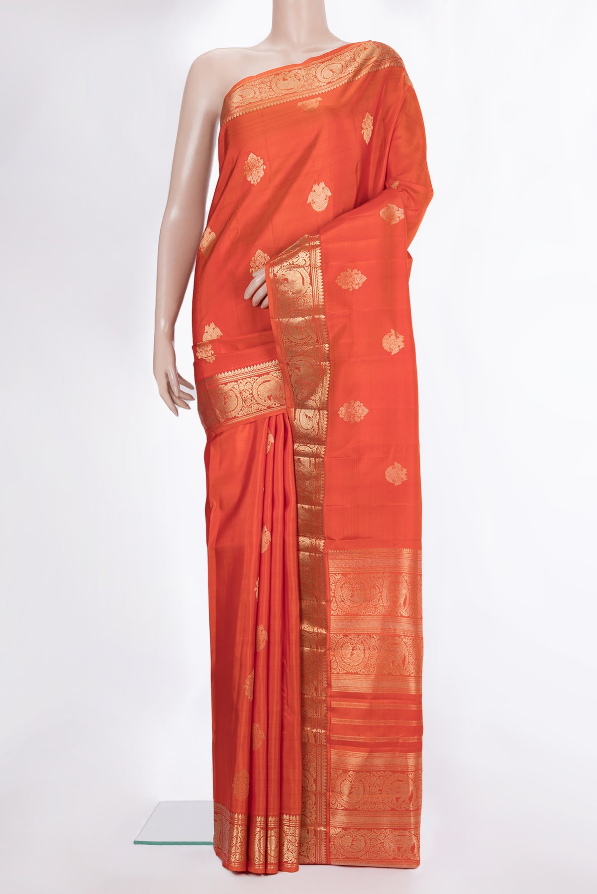Pure Silk Orange Kanjivaram Saree with Zari Butta on the body and Zari Border.  displayed on a mannequin