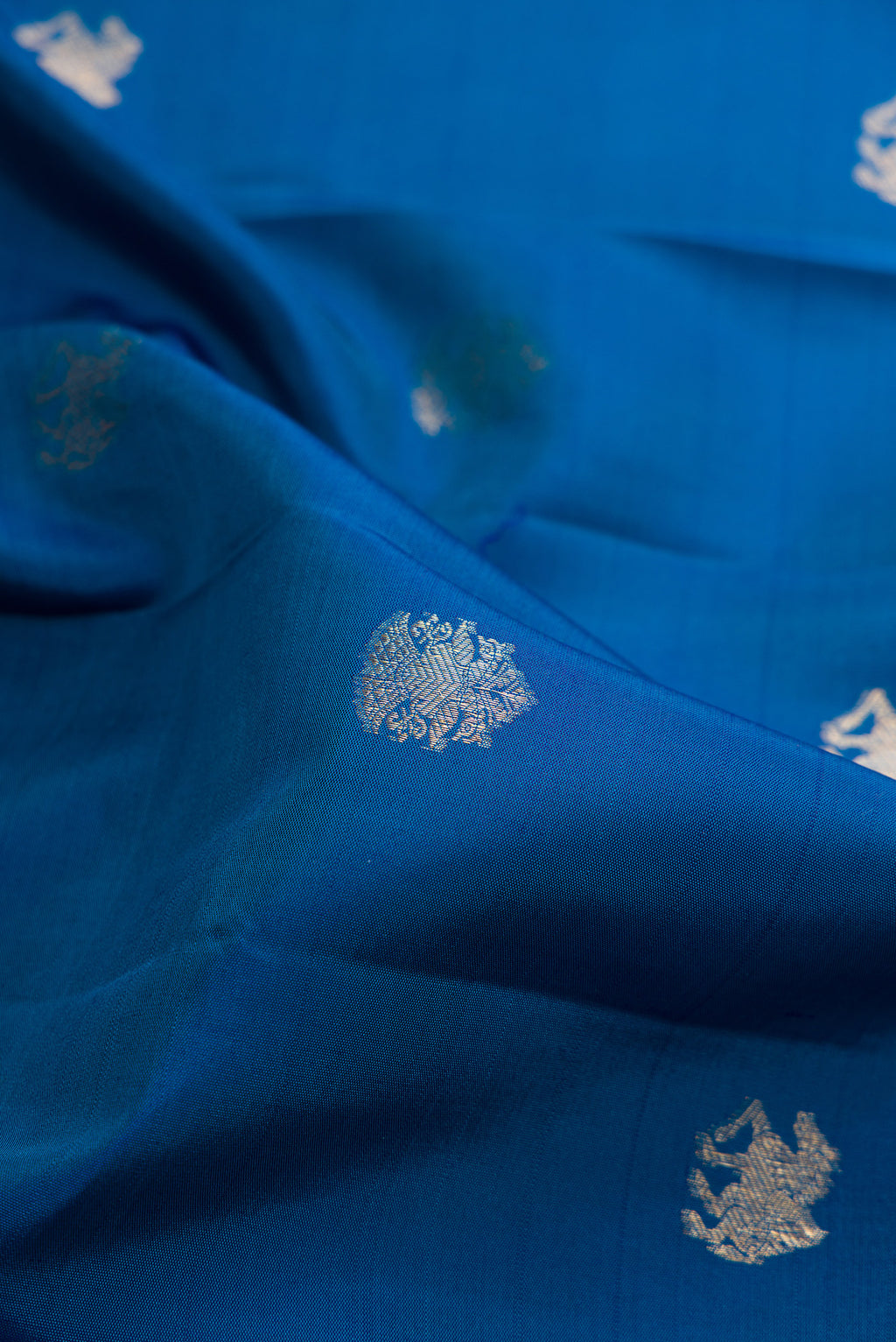 Close up of Pure Silk Blue Kanchipuram Saree with Zari Butta on the body and Zari Border.  displaying folds