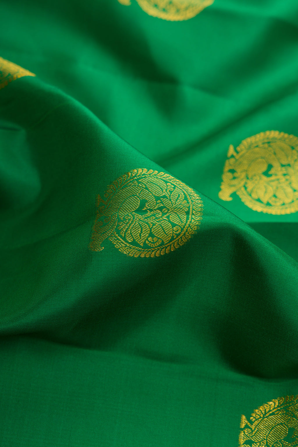 Close up of Pure Silk Green Kanchipuram Saree with Zari Butta on the body and Zari Border.  displaying folds
