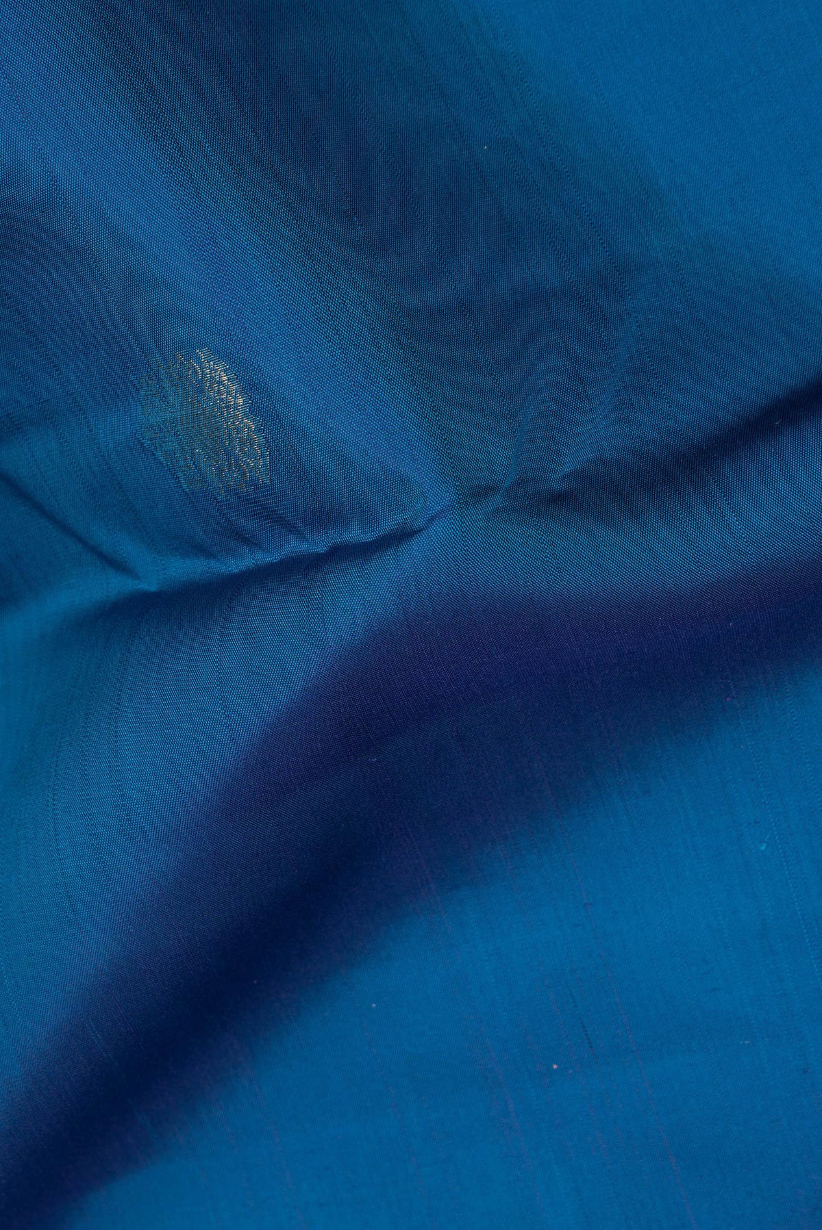 Close up of Pure Silk Peacock Blue Kanchipuram Saree with Zari Butta on the body and Zari Border.  displaying folds