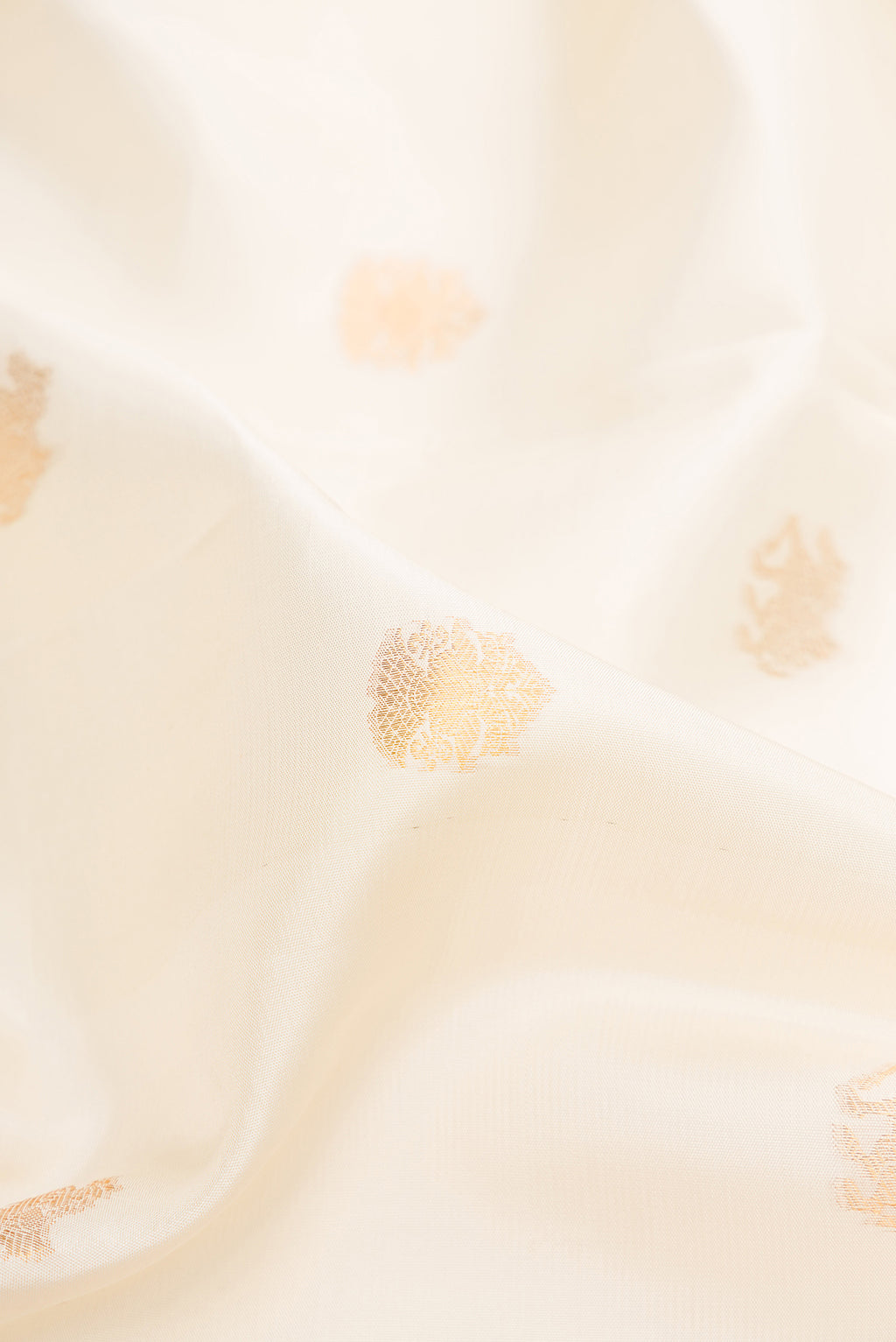 Close up of Pure Silk Off White Kanchipuram Saree with Zari Butta on the body and Zari Border.  displaying folds