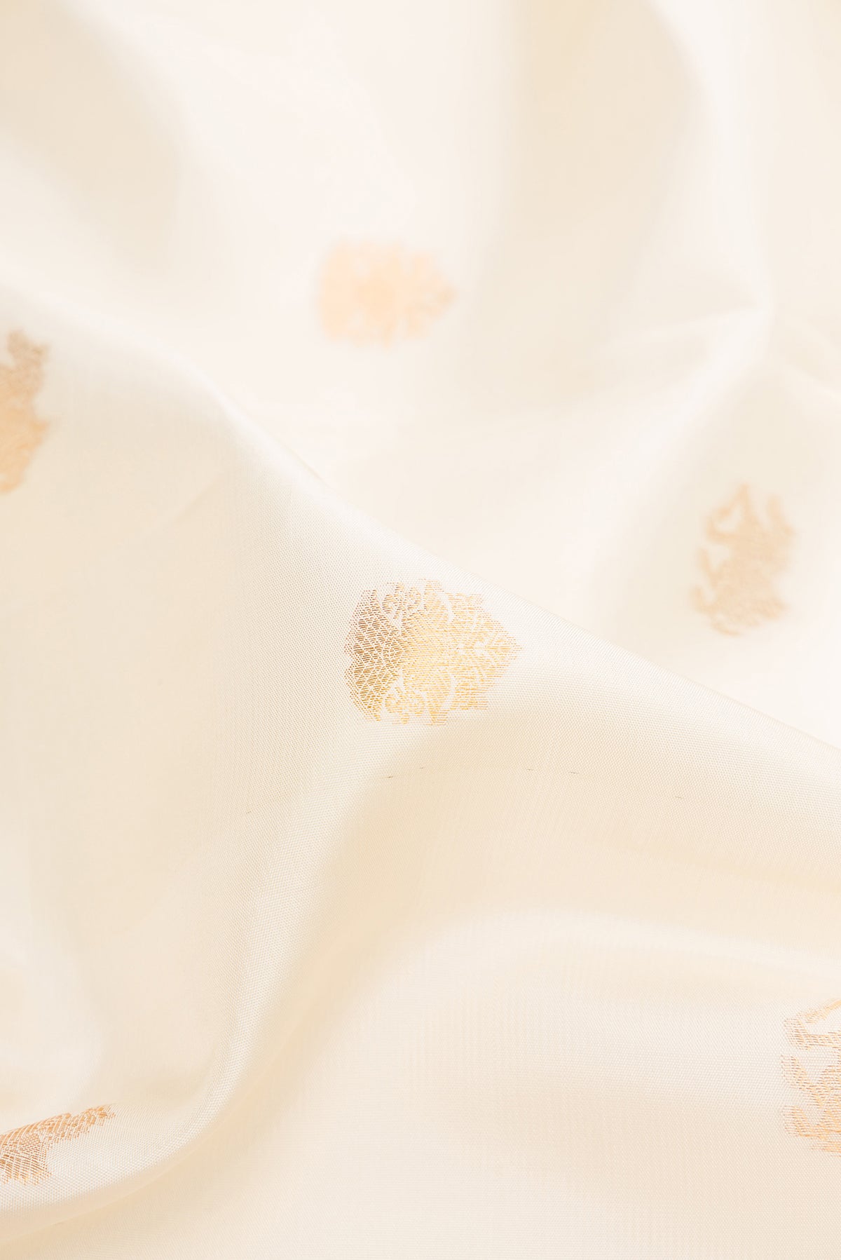 Close up of Pure Silk Off White Kanchipuram Saree with Zari Butta on the body and Zari Border.  displaying folds