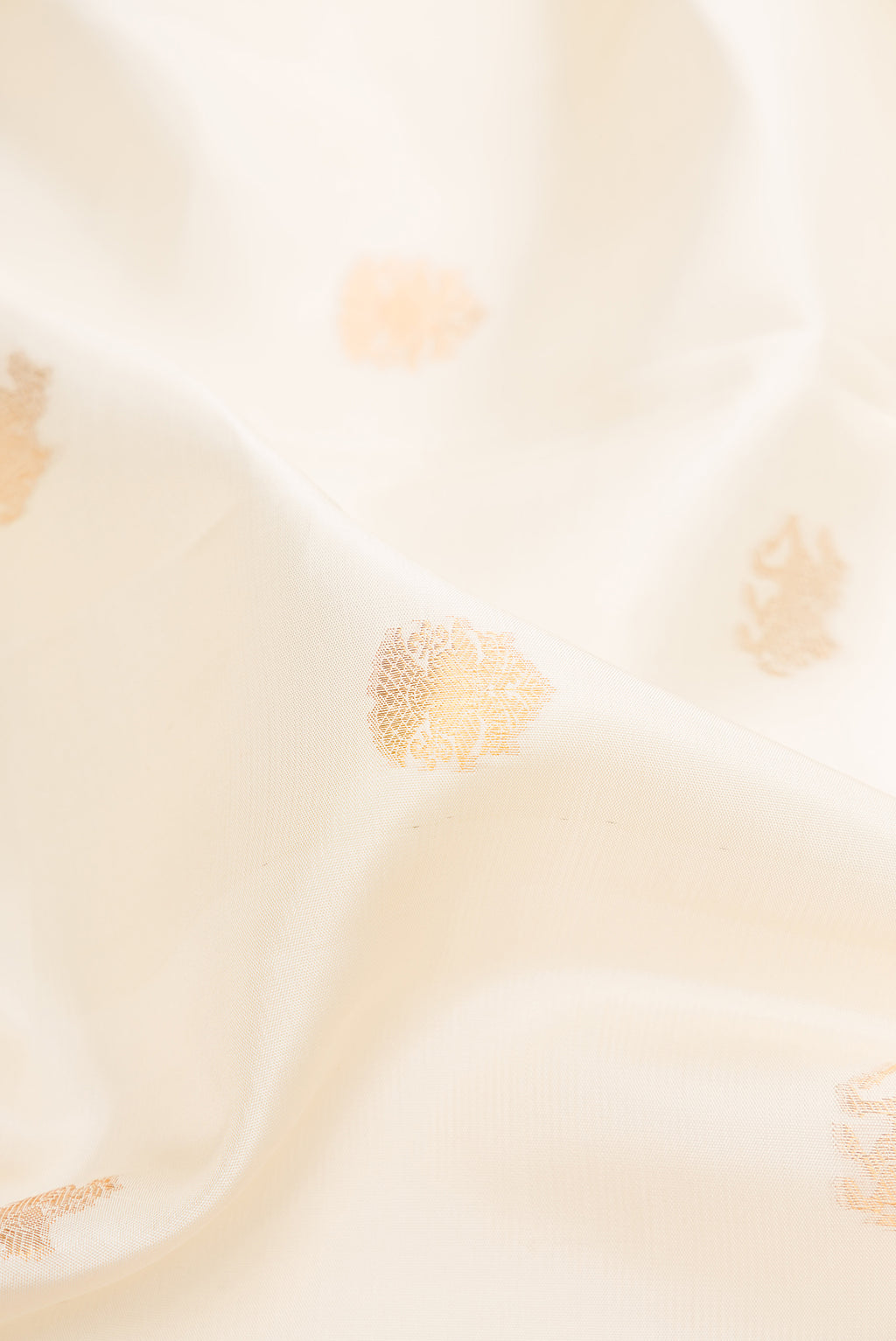 Close up of Pure Silk Off White Kanchipuram Saree with Zari Butta on the body and Zari Border.  displaying folds