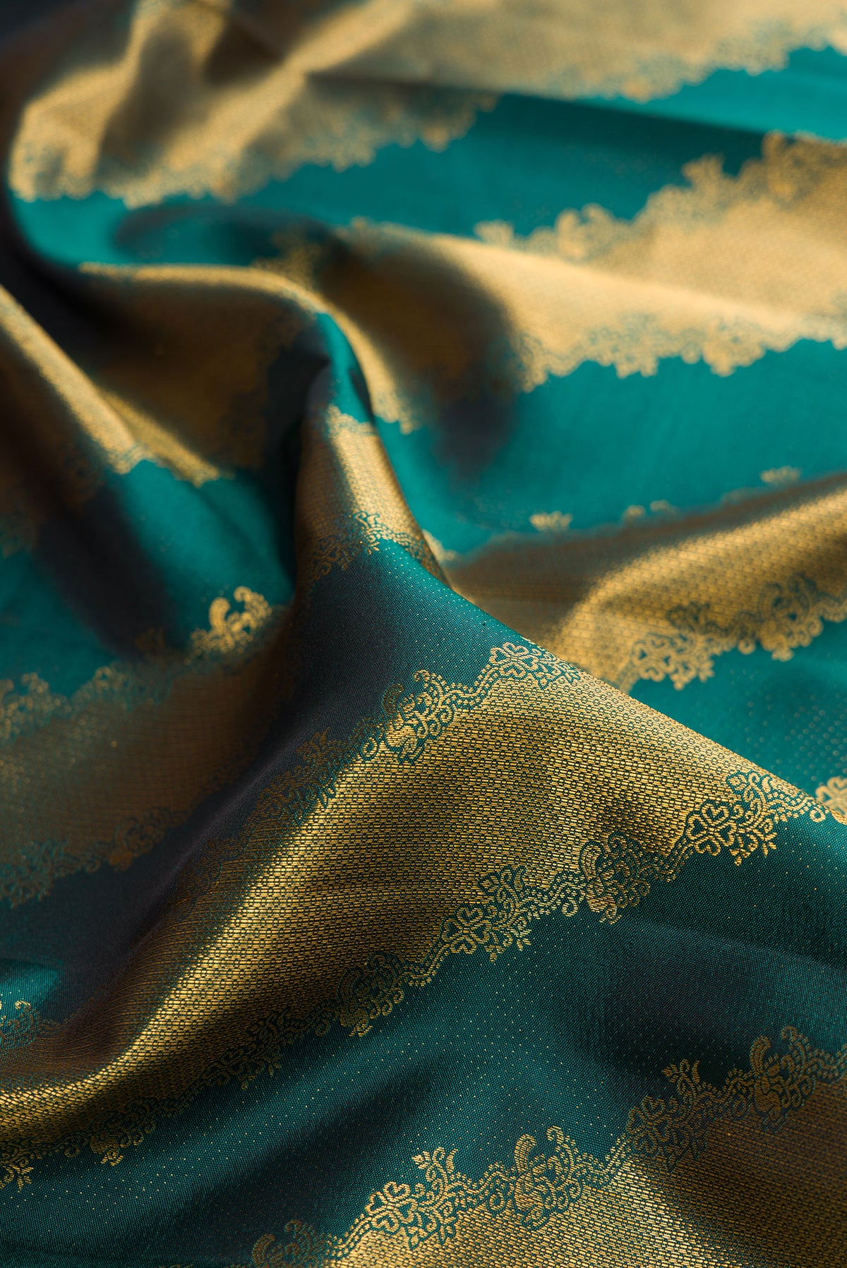 Close up of Pure Silk Bottle Green Kanchipuram Saree with Zari Brocade on the body and Zari Border.  displaying folds