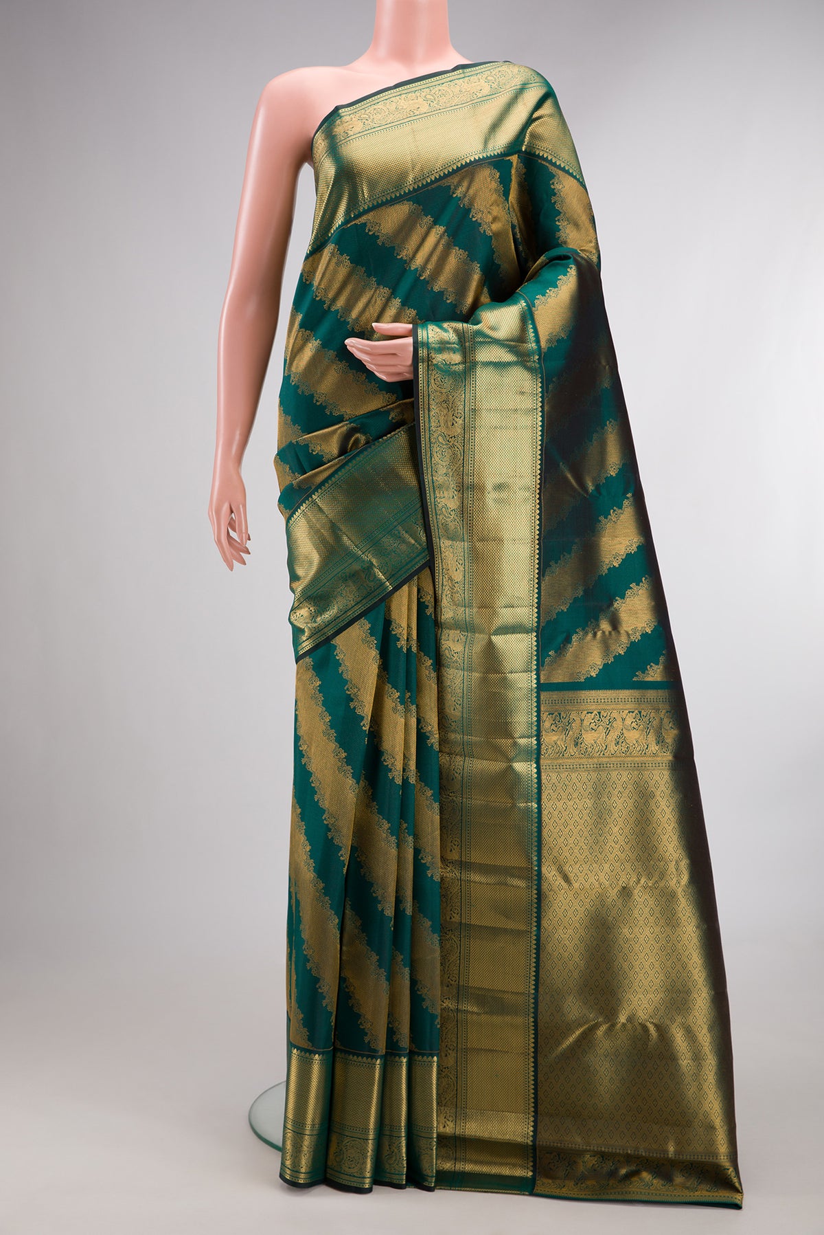Pure Silk Bottle Green Kanchipuram Saree with Zari Brocade on the body and Zari Border.  displayed on a mannequin