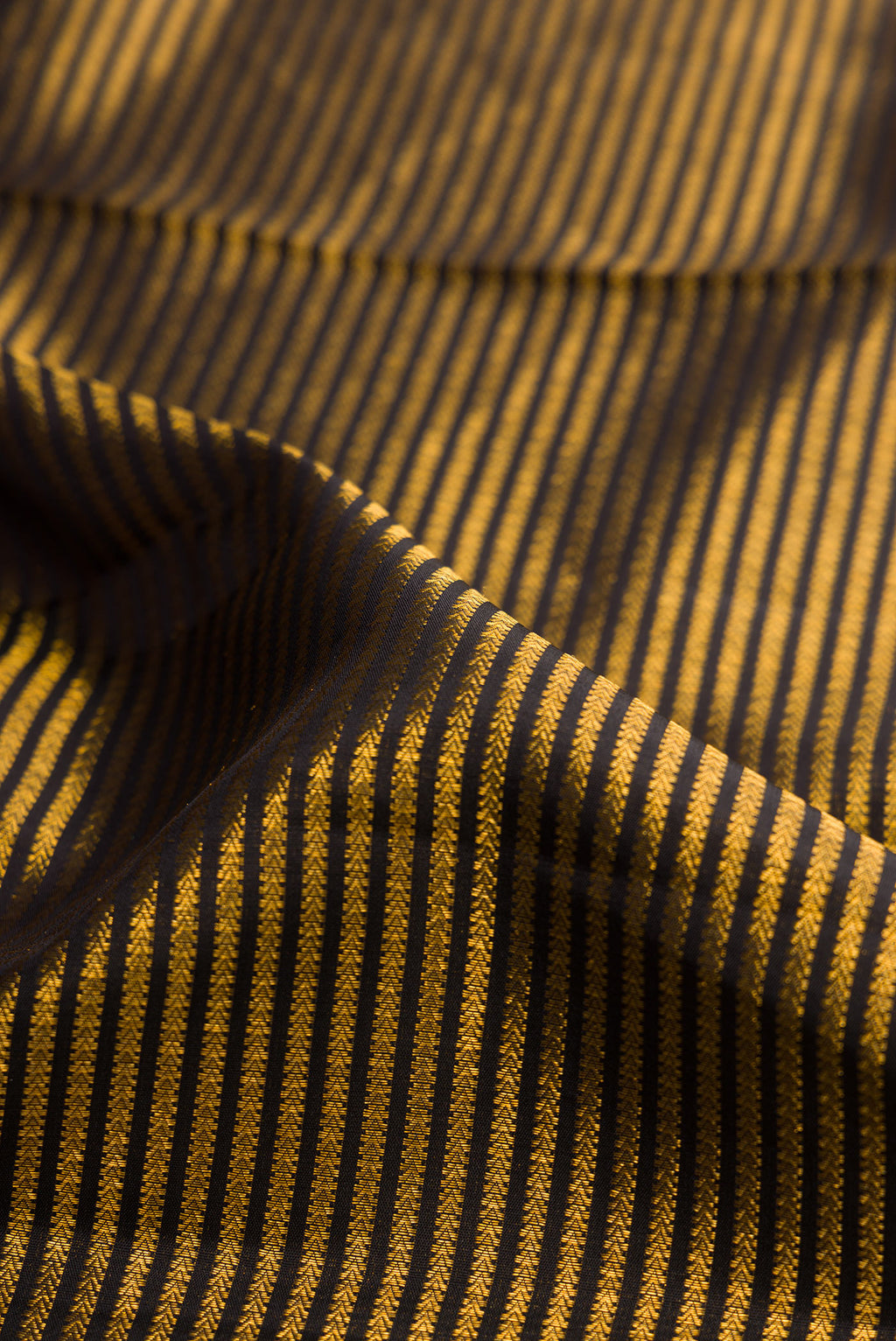 Close up of Pure Silk Black Dual Tone Kanchipuram Saree with Stripes on the body and Fancy Border.  displaying folds