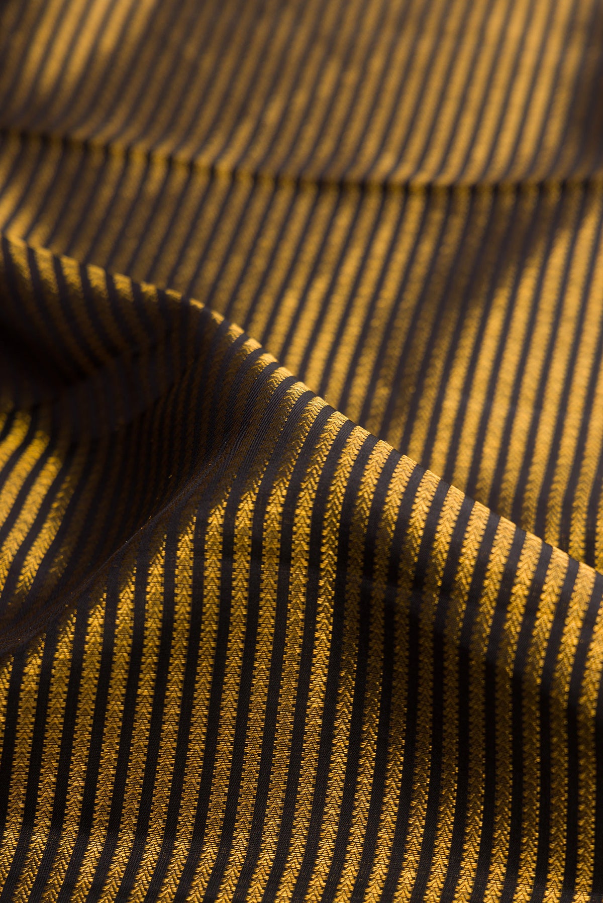 Close up of Pure Silk Black Dual Tone Kanchipuram Saree with Stripes on the body and Fancy Border.  displaying folds
