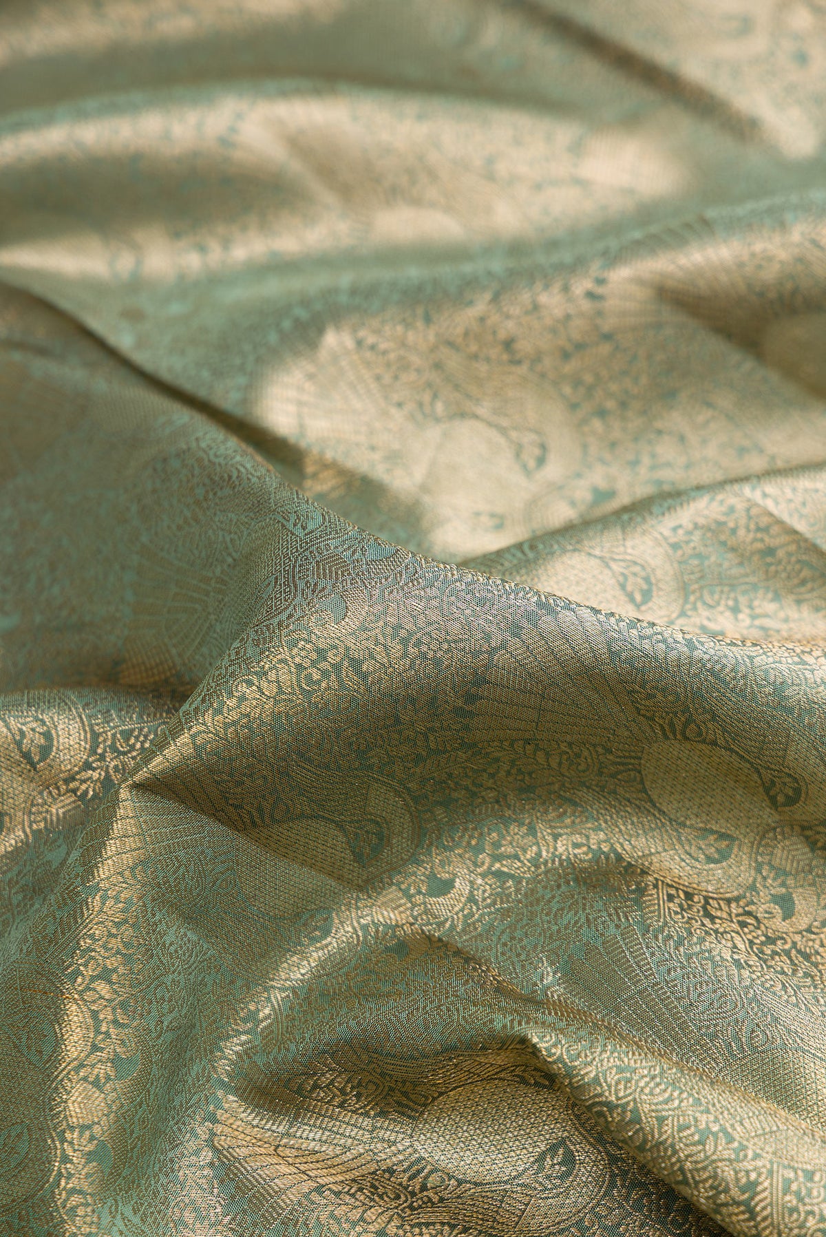 Close up of Pure Silk Green Kanchipuram Saree with Zari Brocade on the body and Zari Border.  displaying folds