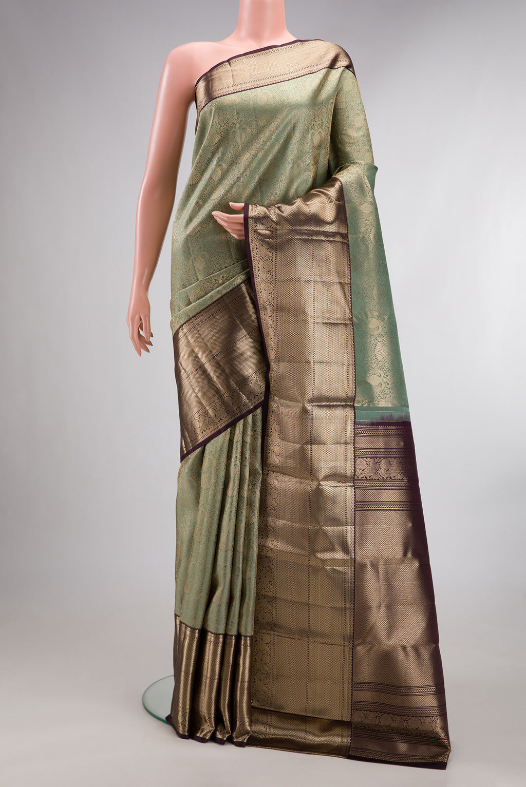 Pure Silk Green Kanchipuram Saree with Zari Brocade on the body and Zari Border.  displayed on a mannequin