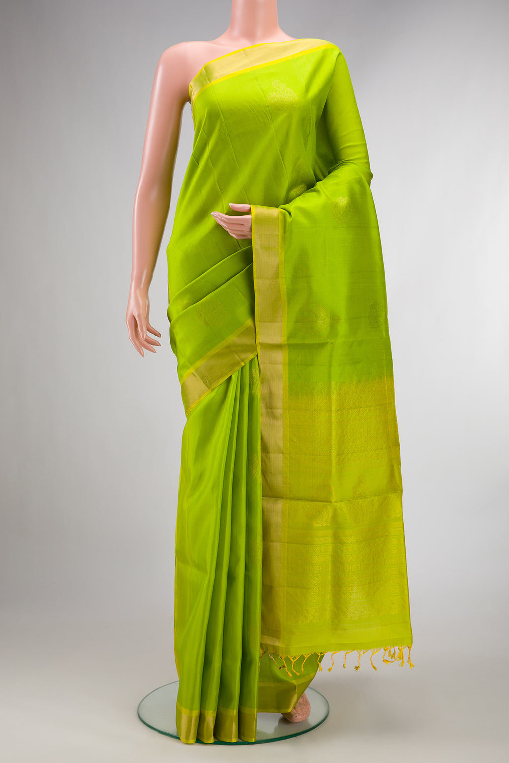 Pure Silk Parrot Green Soft Saree with Zari Butta on the body and Zari Border.  displayed on a mannequin