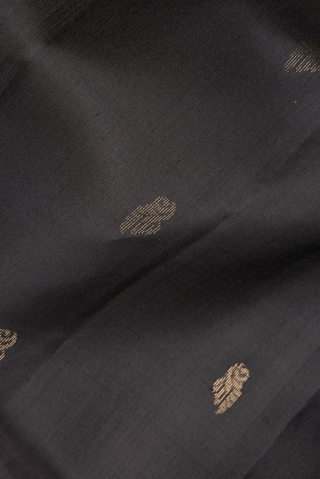 Close up of Pure Silk Black Dual Tone Soft Saree with Zari Butta on the body and Zari Border.  displaying folds