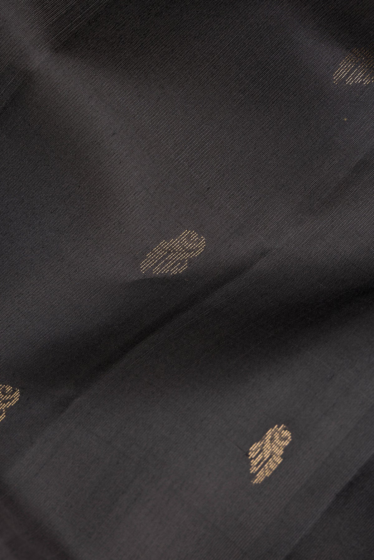 Close up of Pure Silk Black Dual Tone Soft Saree with Zari Butta on the body and Zari Border.  displaying folds
