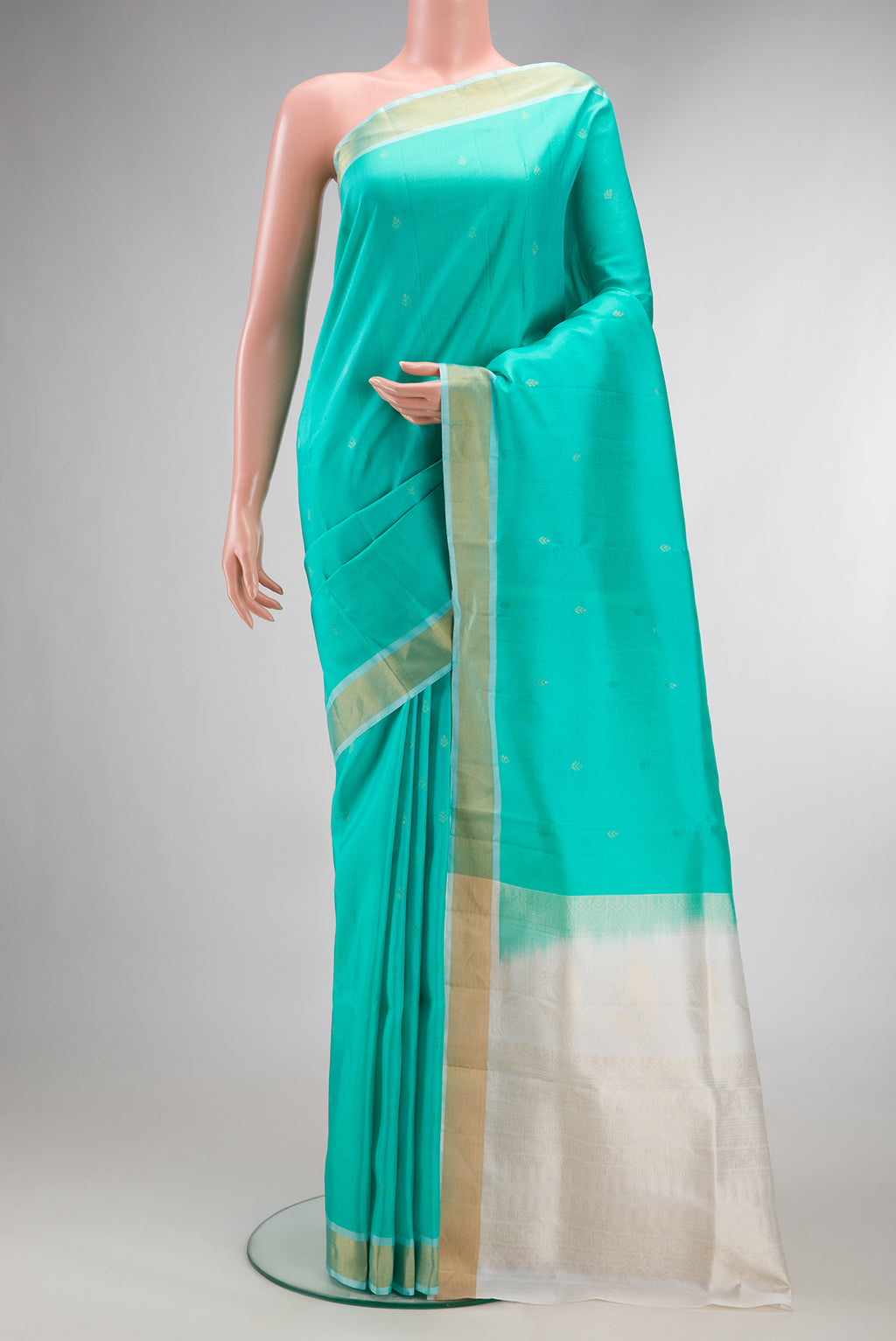 Pure Silk Sea Green Soft Saree with Zari Butta on the body and Zari Border.  displayed on a mannequin