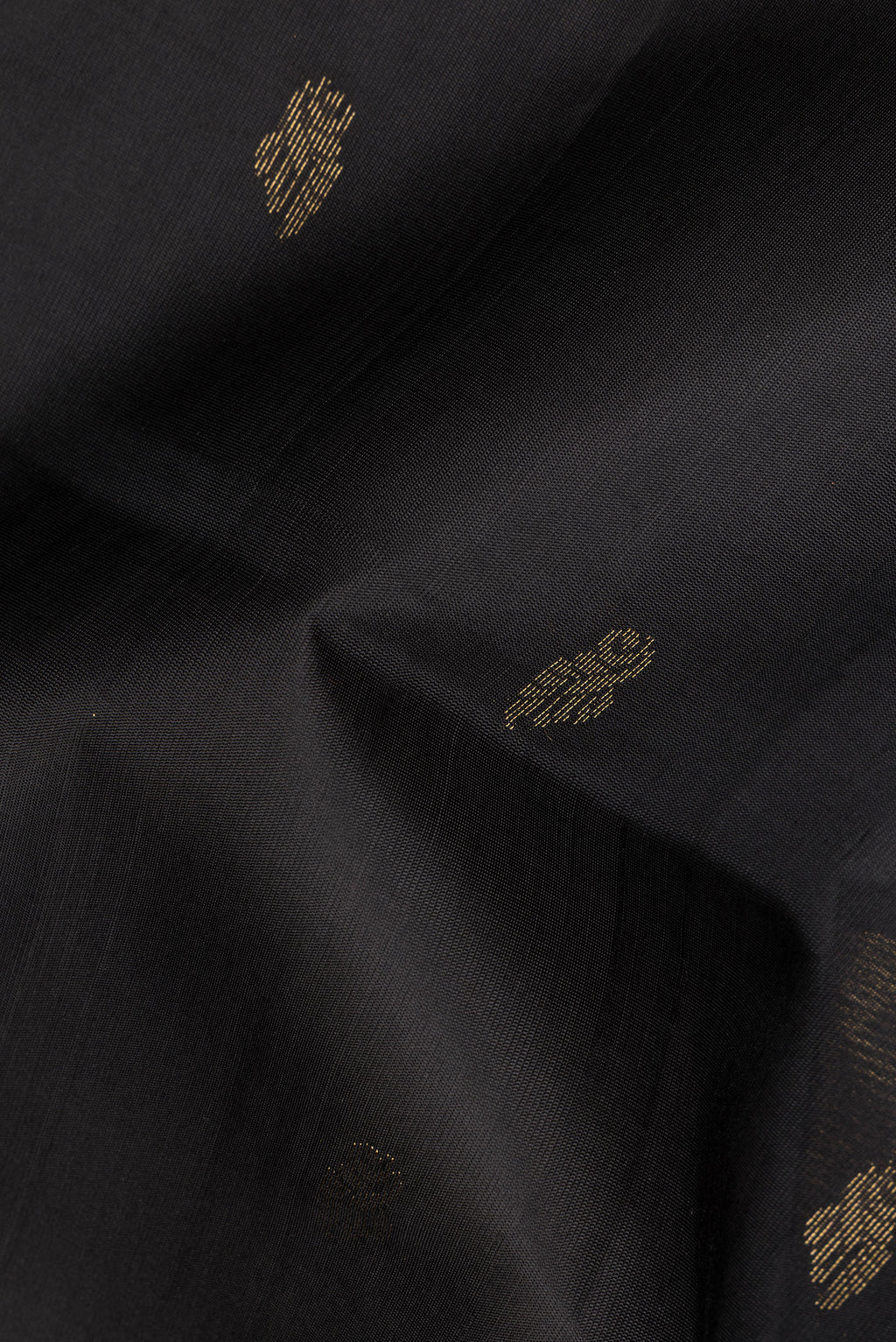 Close up of Pure Silk Black Soft Saree with Zari Butta on the body and Zari Border.  displaying folds