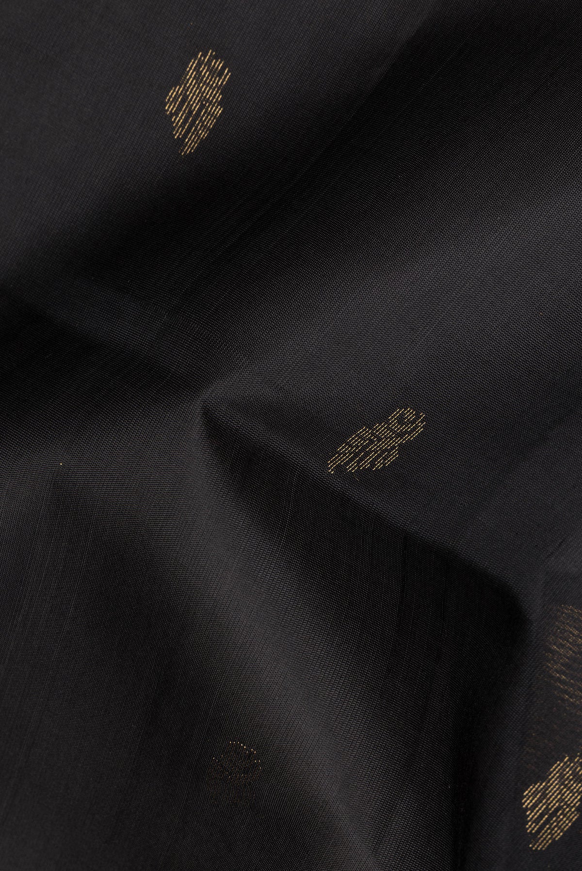 Close up of Pure Silk Black Soft Saree with Zari Butta on the body and Zari Border.  displaying folds