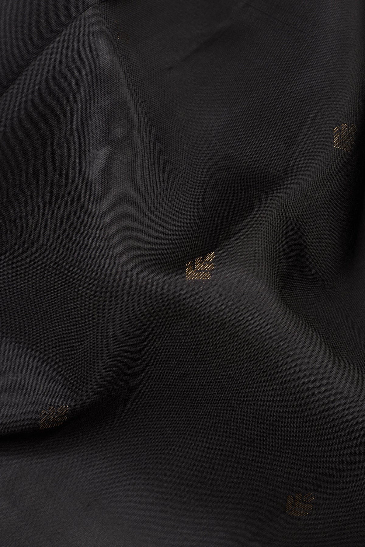 Close up of Pure Silk Black Soft Saree with Zari Butta on the body and Zari Border.  displaying folds