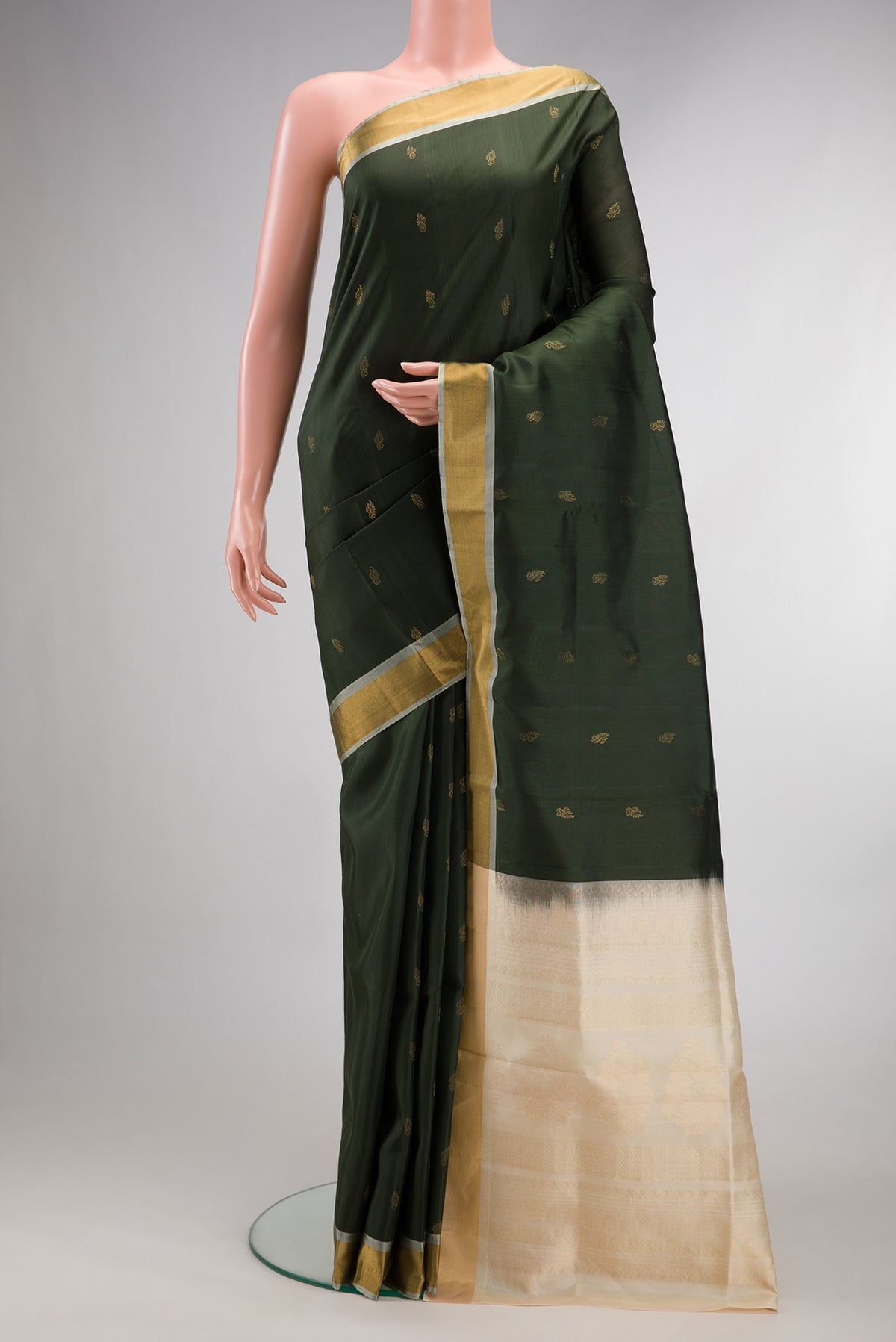 Pure Silk Bottle Green Soft Saree with Zari Butta on the body and Zari Border.  displayed on a mannequin