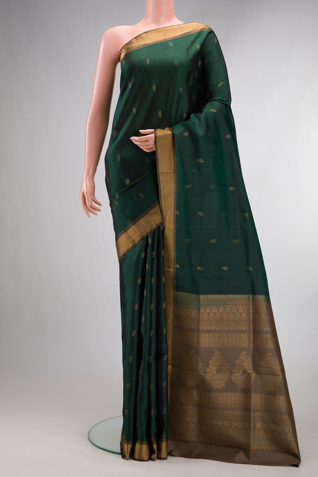 Pure Silk Bottle Green Soft Saree with Zari Butta on the body and Zari Border.  displayed on a mannequin