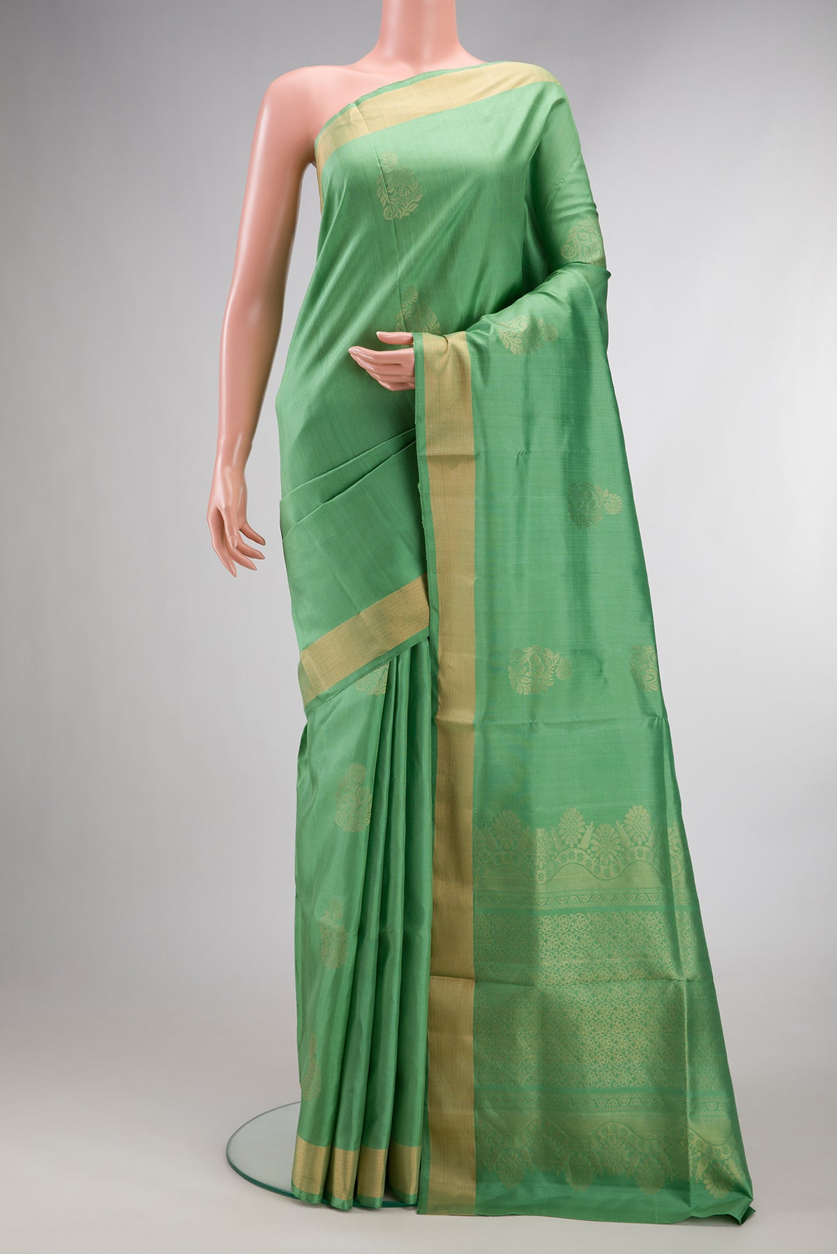 Pure Silk Light Green Soft Saree with Zari Butta on the body and Zari Border.  displayed on a mannequin