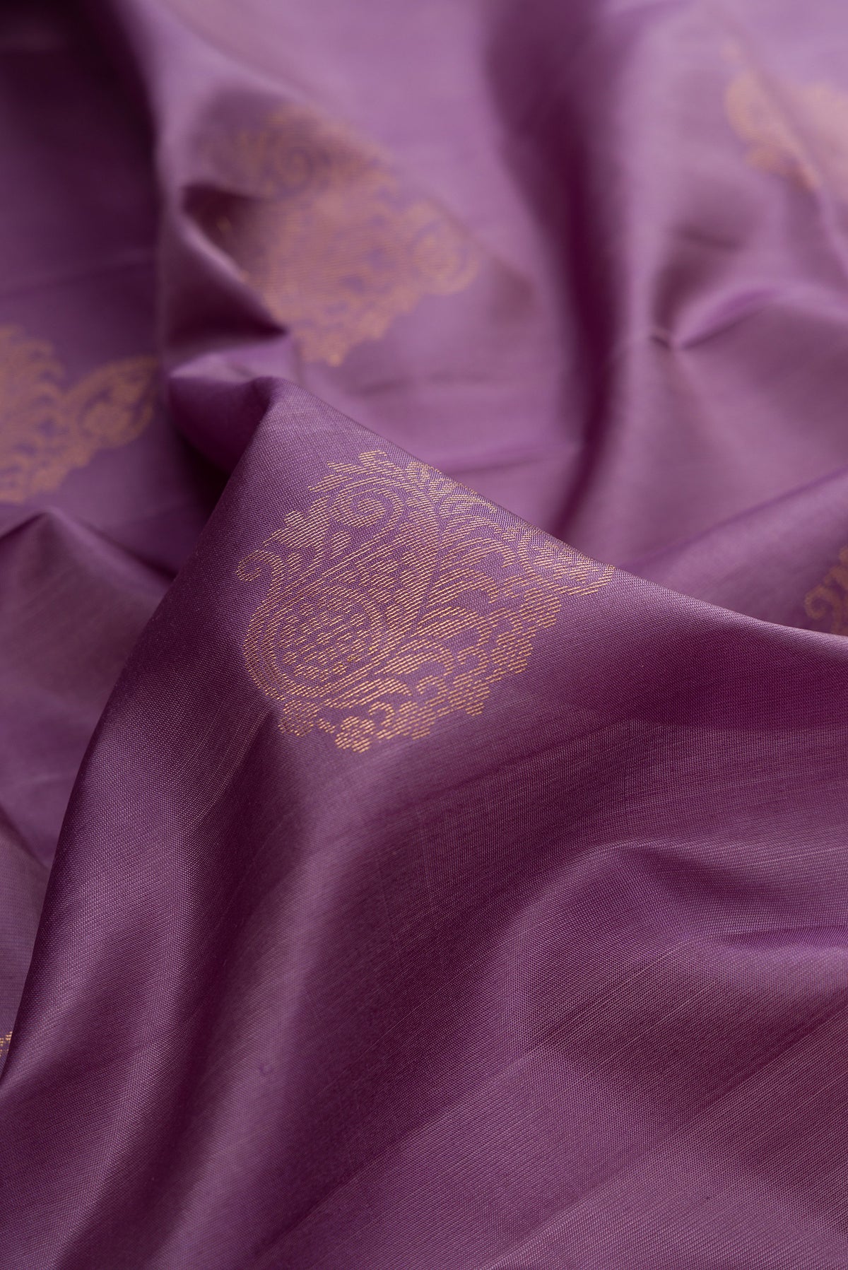 Close up of Pure Silk Mauve Soft Saree with Zari Butta on the body and Zari Border.  displaying folds