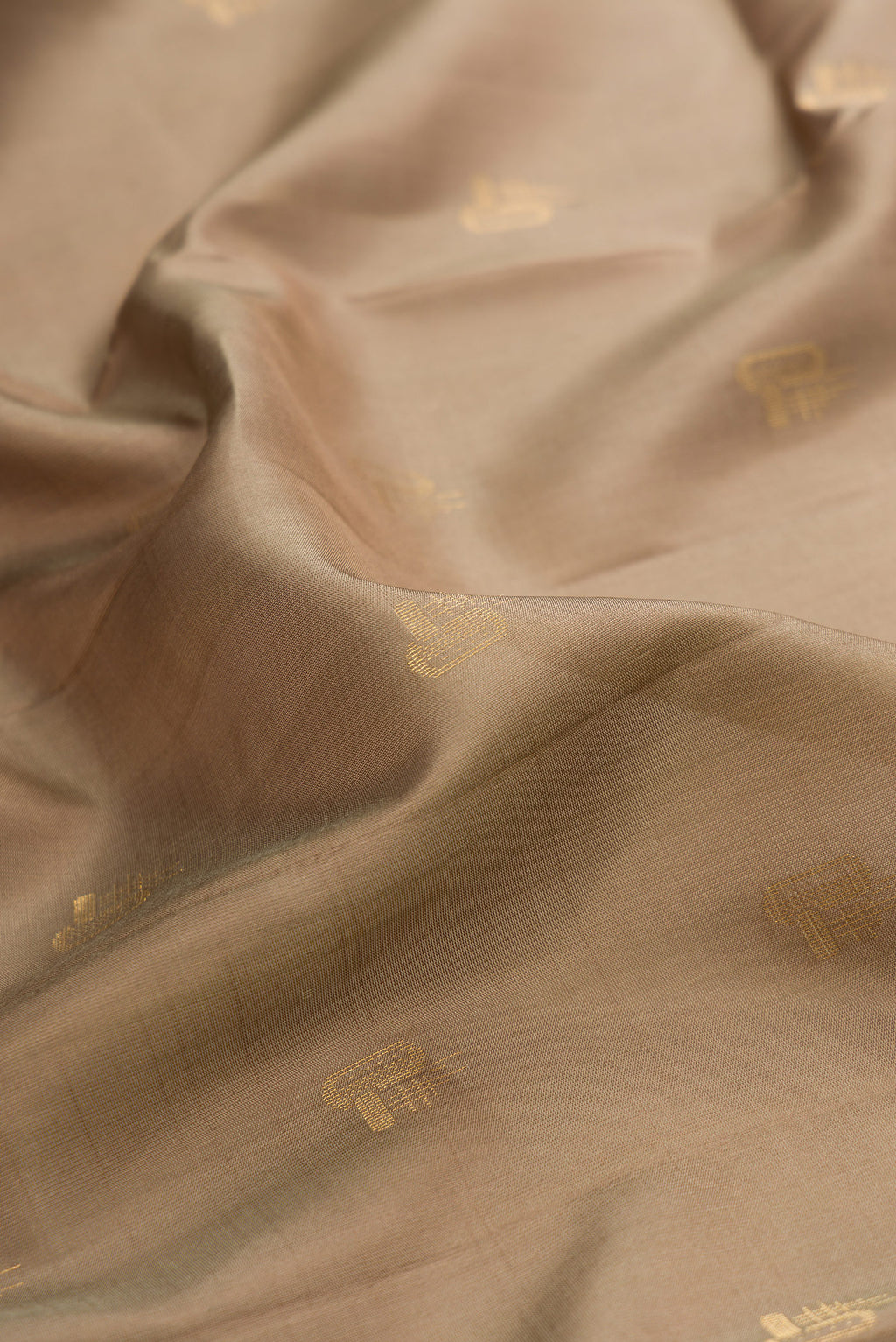 Close up of Pure Silk Brown Soft Saree with Zari Butta on the body and Zari Border.  displaying folds