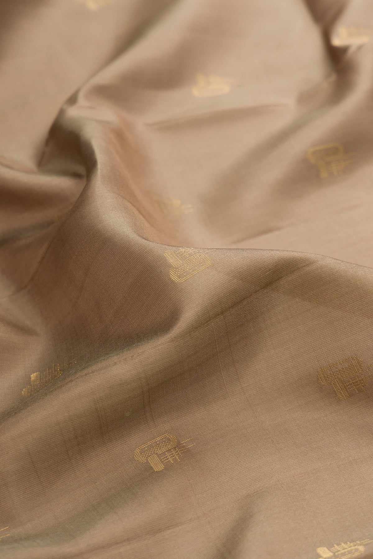 Close up of Pure Silk Brown Soft Saree with Zari Butta on the body and Zari Border.  displaying folds