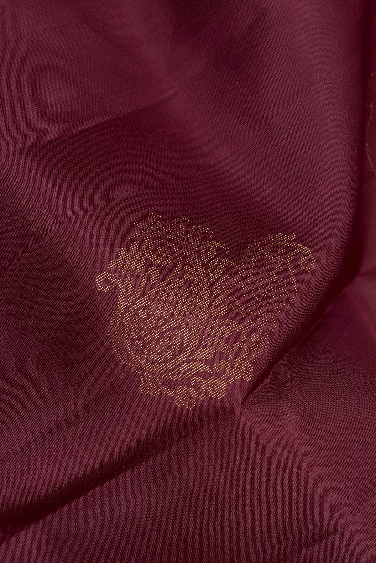 Close up of Pure Silk Brown Soft Saree with Zari Butta on the body and Zari Border.  displaying folds