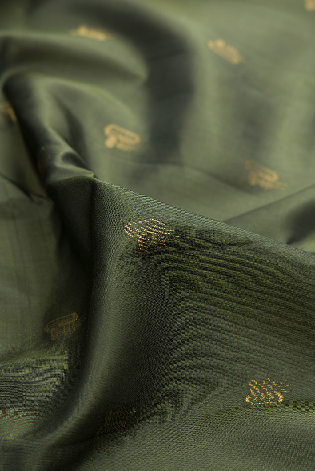 Close up of Pure Silk Olive Green Soft Saree with Zari Butta on the body and Zari Border.  displaying folds