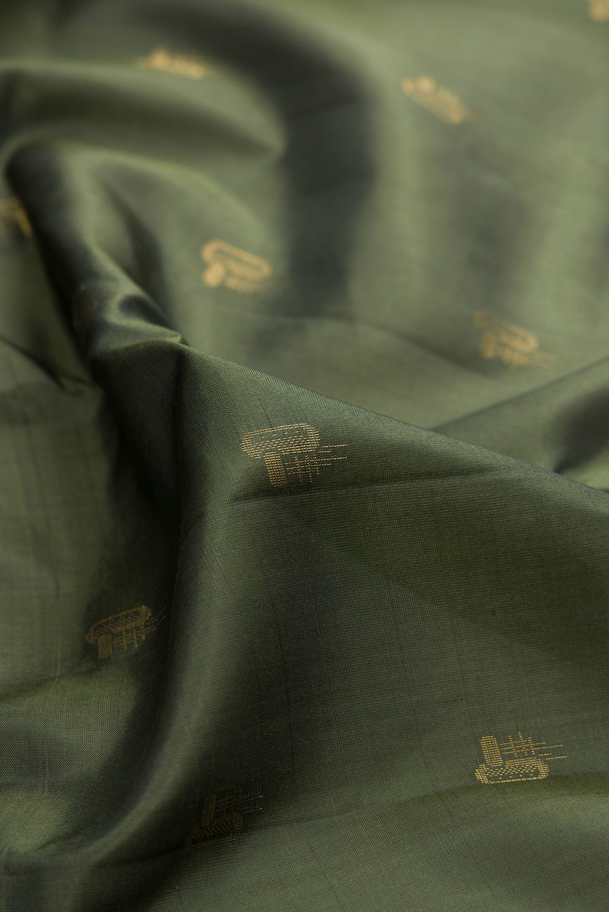 Close up of Pure Silk Olive Green Soft Saree with Zari Butta on the body and Zari Border.  displaying folds