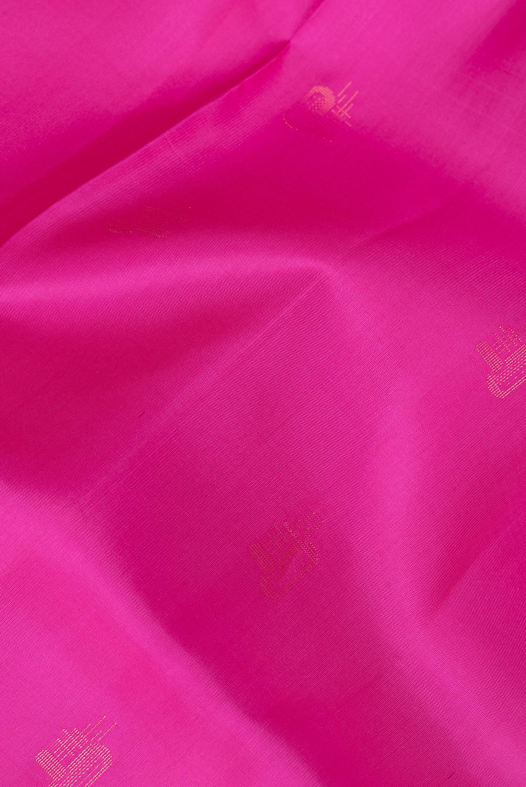 Close up of Pure Silk Rani Pink Soft Saree with Zari Butta on the body and Zari Border.  displaying folds