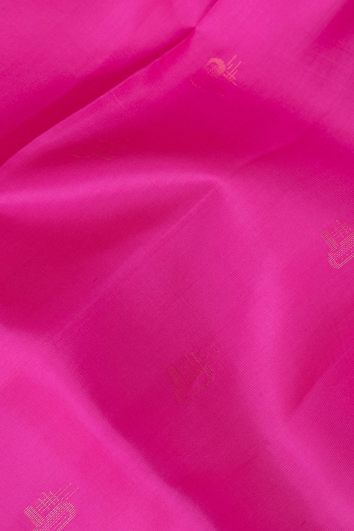 Close up of Pure Silk Rani Pink Soft Saree with Zari Butta on the body and Zari Border.  displaying folds