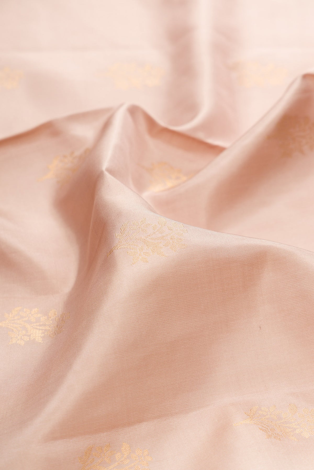 Close up of Pure Silk Beige Soft Saree with Zari Butta on the body and Zari Border.  displaying folds