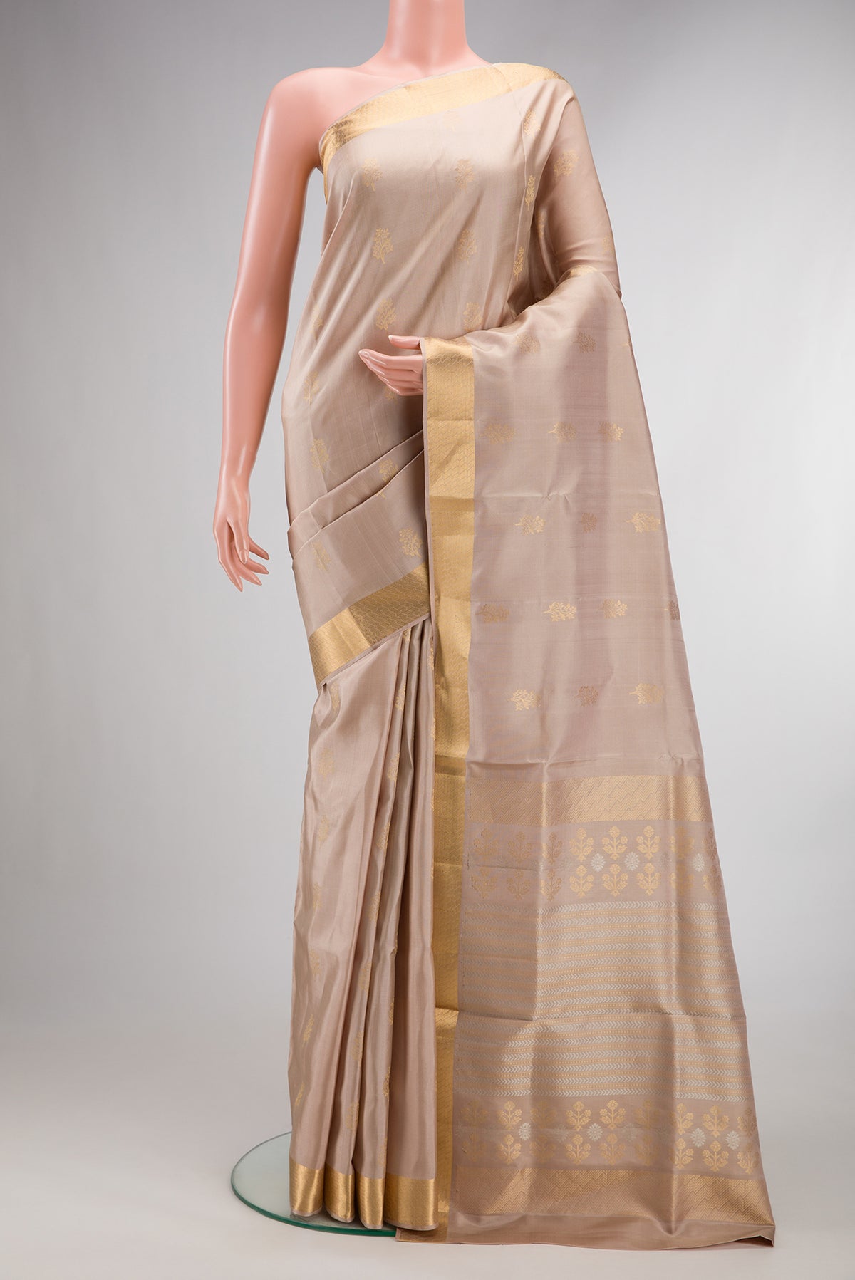 Pure Silk Beige Soft Saree with Zari Butta on the body and Zari Border.  displayed on a mannequin