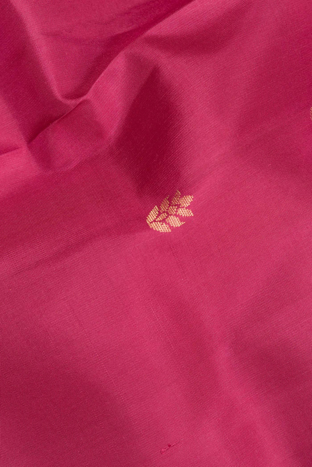 Close up of Pure Silk Pink Soft Saree with Zari Butta on the body and Zari Border.  displaying folds
