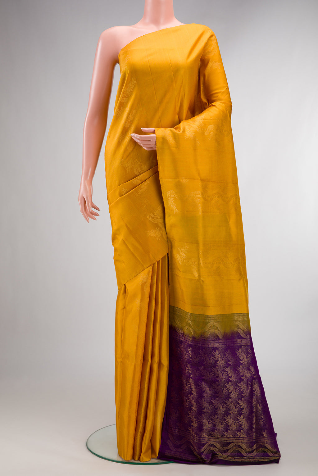 Pure Silk Mustard Soft Saree with Zari Butta on the body and Without Border.  displayed on a mannequin