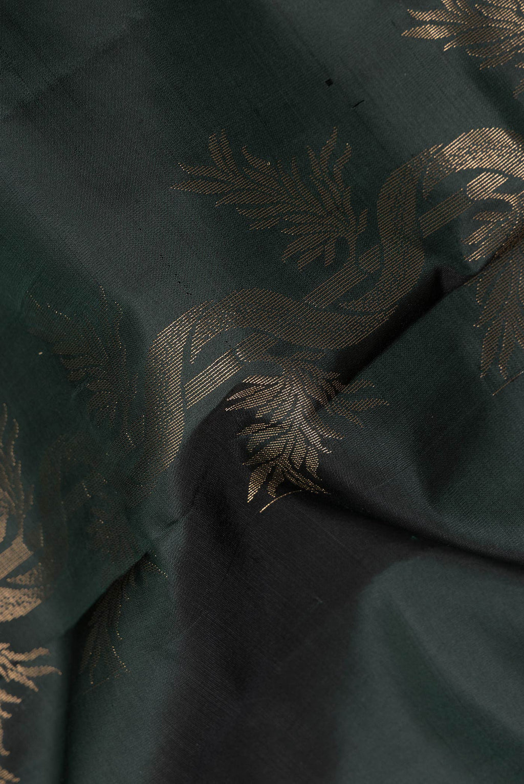 Close up of Pure Silk Bottle Green Soft Saree with Zari Butta on the body and Zari Border.  displaying folds